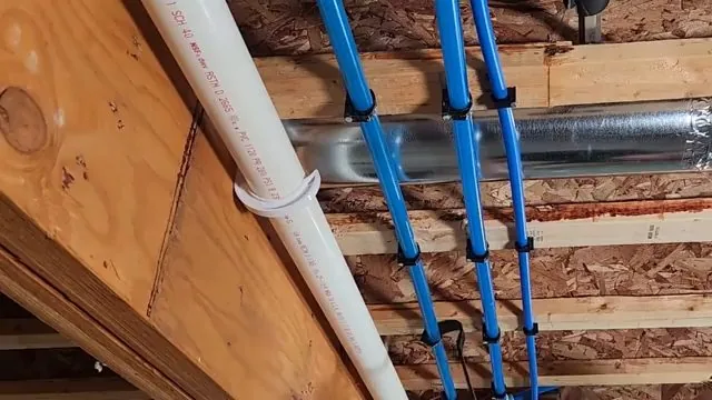 Blue PEX water lines clipped along ceiling joists in a basement, beside a white PVC drain stack.