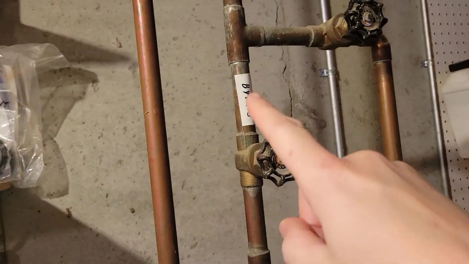 Copper supply pipes with two shutoff valves in place beside a water heater connection.